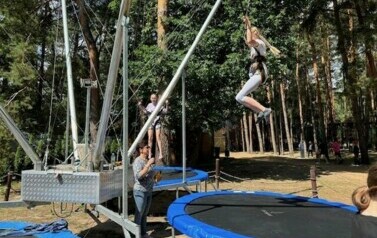 Dzieci skaczą na trampolinie.