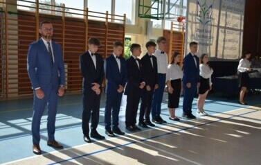 Uczniowie klasy &oacute;smej wraz z wychowawcą podczas uroczystości zakończenia roku szkolnego