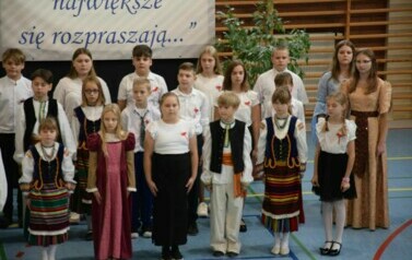 Uczniowie klas IV-VIII w strojach galowych i ludowych.