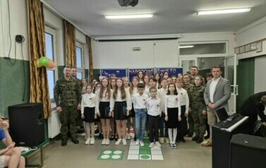 Zdjęcie ch&oacute;ru szkolnego z ż&oacute;łłnierzami i dyrekcją plac&oacute;wki.