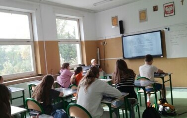 Uczniowie czytają tekst opowiadania wyświetlony na monitorze.