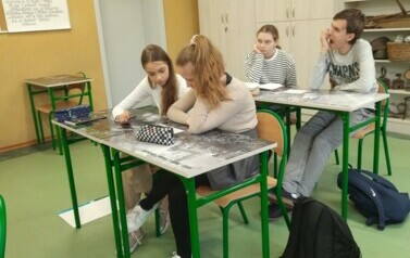 Uczniowie klasy &oacute;smej czytają treść opowiadania Uczciwy wolontariat.
