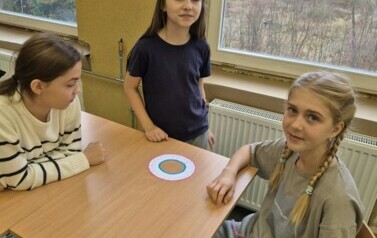 Uczennice klasy piątej układają domino matematyczne.