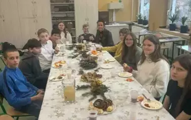 Uczniowie klasy sz&oacute;stej przy stole wigilijnym
