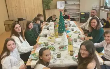 Uczniowie klasy si&oacute;dmej z wychowawcą przy wigilijnym stole
