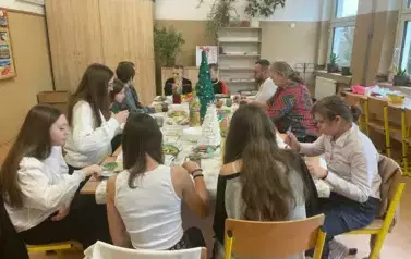 Uczniowie klasy si&oacute;dmej z nauczycielami przy wigilijnym stole
