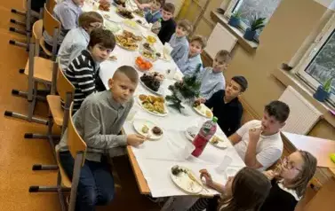Uczniowie klasy czwartej z nauczycielami przy wigilijnym stole