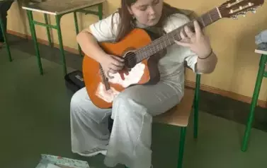 Uczennica gra na gitarze