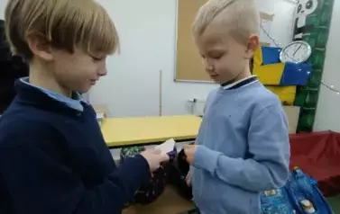 Chłopcy z klasy pierwszej przełamują opłatek