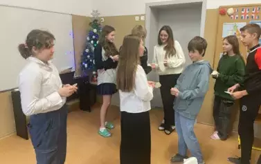 Uczniowie klasy si&oacute;dmej dzielą się opłatkiem i składają życzenia