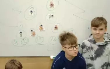 Chłopcy stojący przy świątecznej choince matematycznej