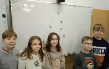 Uczniowie stojący przy świątecznej choince matematycznej