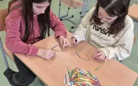 Dziewczynki układają tr&oacute;jkąty z kolorowych patyczk&oacute;w