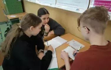 Grupa uczni&oacute;w rozwiązuje zadania walentynkowe.