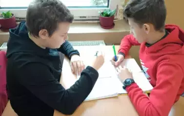 Chłopcy rozwiązują zadania walentynkowe.