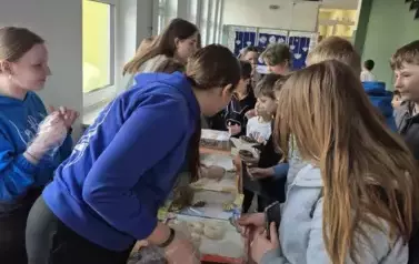 Uczniowie szkoły podstawowej kupują pączki