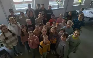 Uczniowie szkoły podstawowej na korytarzu szkolnym z szalonymi fryzurami na głowach