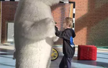 Biały miś tańczy z chłopcem