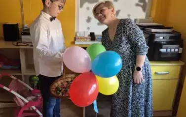 Chłopiec częstuje cukierkami kobietę w sukience
