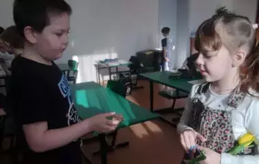 Chłopiec wręcza prezent koleżance z klasy