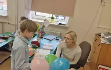 Uczeń klasy czwartej składa życzenia z okazji Dnia Kobiet wychowawczyni klasy pierwszej