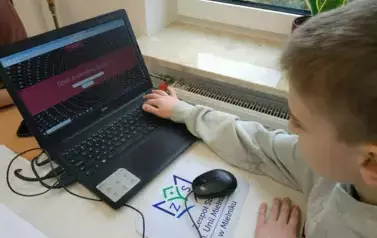 Uczeń siedzący przy laptopie