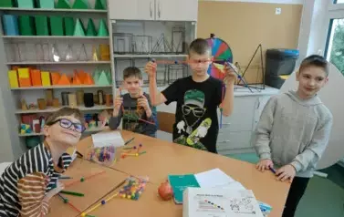 Uczniowie stojący i pokazujący swoją bryłę