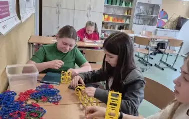 Dziewczynki konstruują liczbę Pi z kolorowych kloch&oacute;w w kształcie kwadrat&oacute;w, tr&oacute;jkąt&oacute;w i innych figur geometrycznych