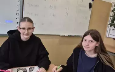Dwie uczennice w sali matematycznej wykonują mandalę z okazji Dnia Liczby Pi