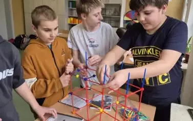 Kilku chłopc&oacute;w konstruuje liczbę Pi z kolorowych patyczk&oacute;w
