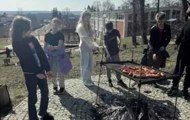 Uczniowie pieką kiełbaski na ognisku