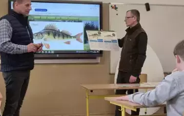 Dw&oacute;ch mężczyzn prezentuje informacje o rybach