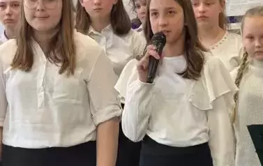 Dziewczynka z mikrofonem w ręku śpiewa.