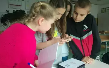 Uczniowie odkrywajacy kod na kom&oacute;rce do otwarcia skrzyneczki z zającem