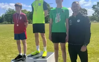 Trener z chłopcami, kt&oacute;rzy zajęli miejsca na podium w zawodach sportowych