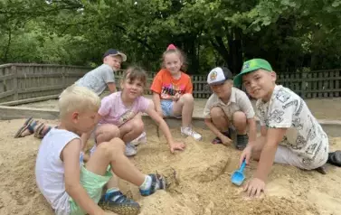 Sześcioro dzieci bawi się w piaskownicy