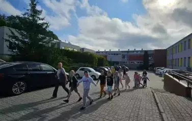 Dzieci z klasy trzeciej wraz z wychowawcą wychodzą ze szkoły