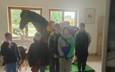 Uczniowie pozują na tle figury konia
