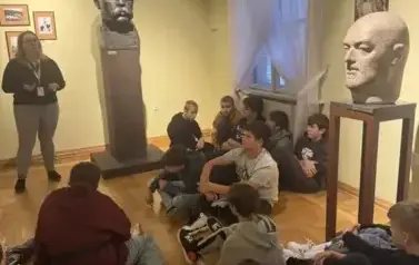 Uczestnicy wycieczki z uwagą słuchają wykładu o rzeźbach