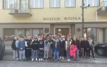 Uczestnicy wycieczki pozują do zdjęcia przy budynku Muzeum Wojska