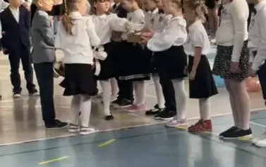 Uczniowie klasy drugiej wręczja upominki pierwszoklasistom