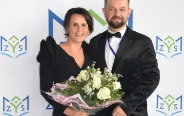 Prowadząca wraz z solistą pozują naa ściance
