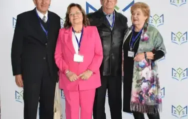 Absolwenci szkoły pozuja na ściance