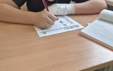 Chłopiec rozwiązuje zadania na kartce