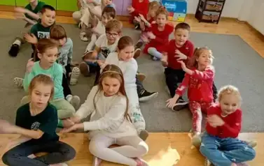 Uczniowie klasy pierwszej ubrani w kolory włoskiej flagi pozują do zdjęcia