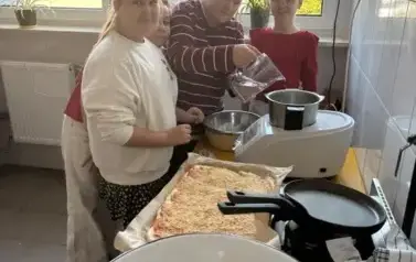 Trzy dziewczynki przygotowują ciasto na pizzę