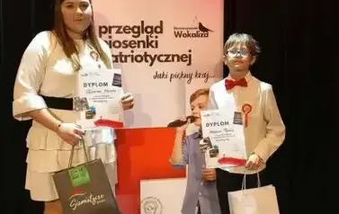 Laureci konkursu wokalnego pozują do zdjęcia z nagrodami