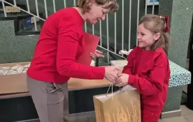 Dziewczynka odbiera nagrodę za zwycięstwo w konkursie plastycznym