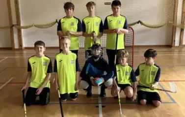 Uczniowie ubrani w stroje sportowe pozują do zdjęcia