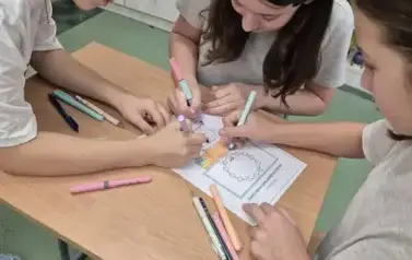 Trzy dziewczynki koloruja matematyczną sowę
